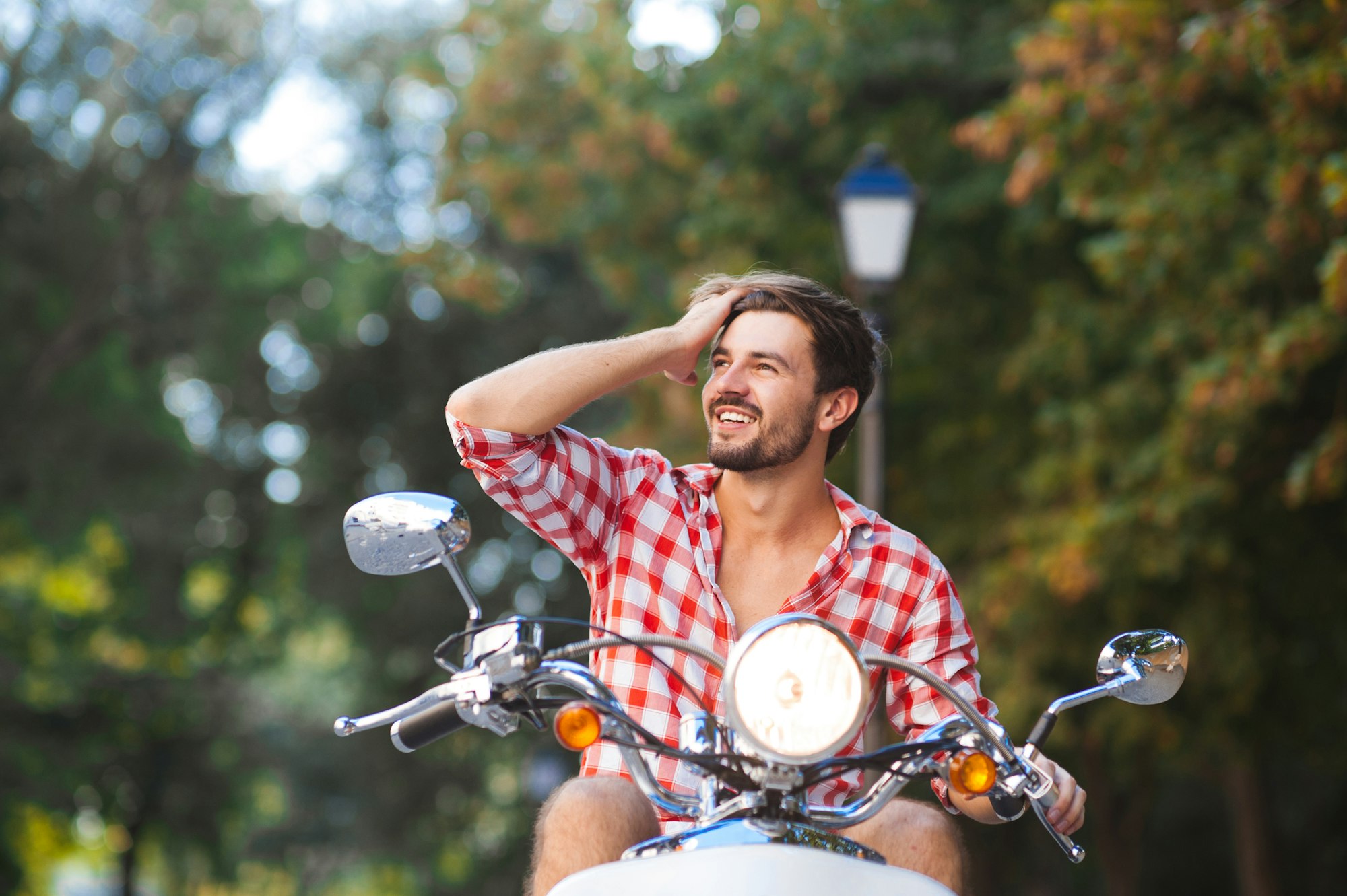 fashionable young man riding a vintage scooter